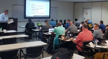 A classroom full of adults with laptops